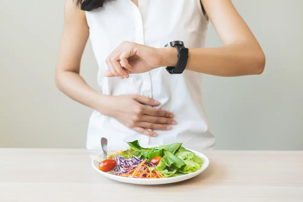 Intermittent fasting for gut health, temptation hungry of breakfast food in morning on table at home, woman looking at watch on her wrist but not yet time to eat