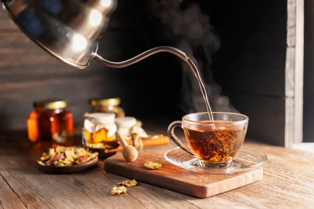 Make a cup of hot tea or a glass of herbal tea. Herbs lay on the wooden table Pouring healthy drinks, herbal drinks and medical concept